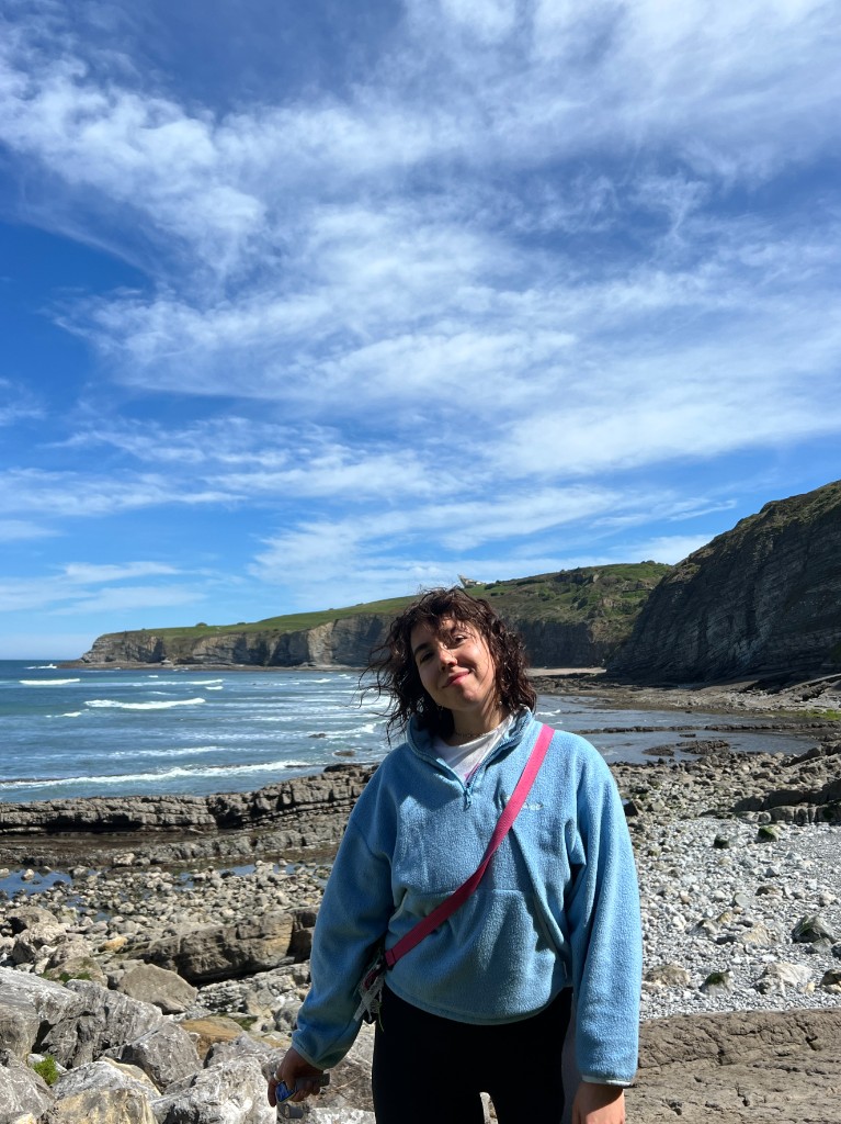 Даша Левадная в голубой толстовке у океана